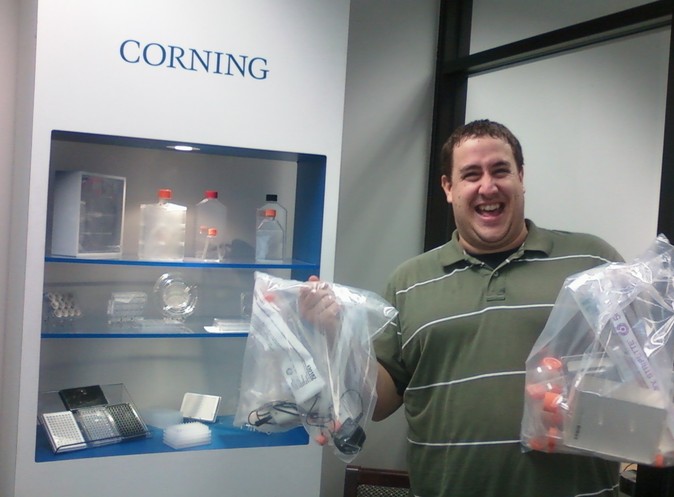 Jeremy Miller shows off bags of lab equipment donated by Corning